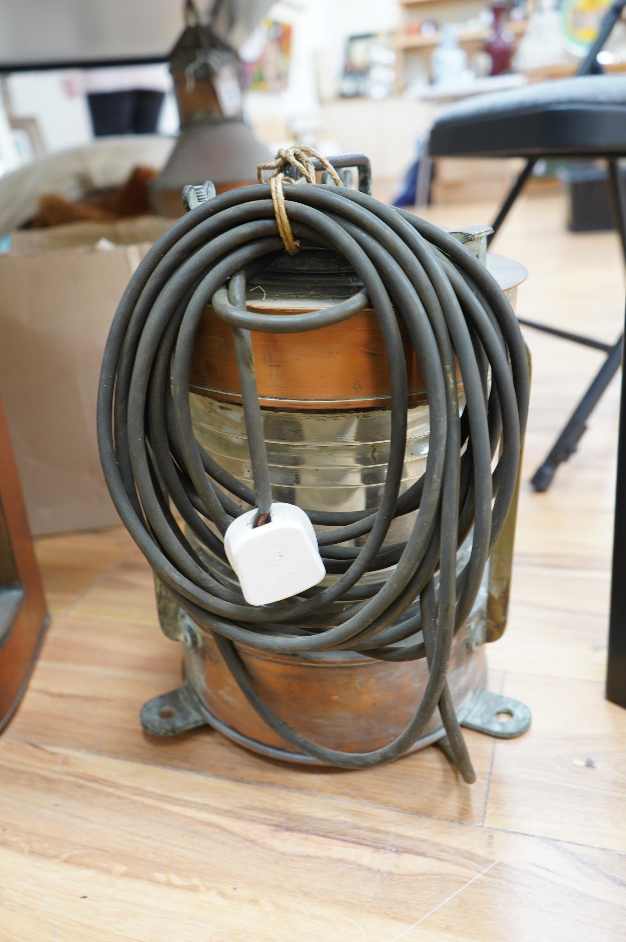 An early 20th century ship’s copper mast head lamp, and another copper ship’s lamp, largest 69cm high. Condition - fair